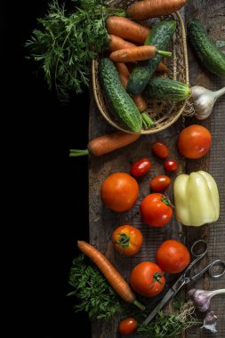 Rustik ayarı, domates, havuç ve salatalık yemek pişirmek için taze malzemeler. Doğal organik sağlıklı gıda kavramı. Üstten görünüm