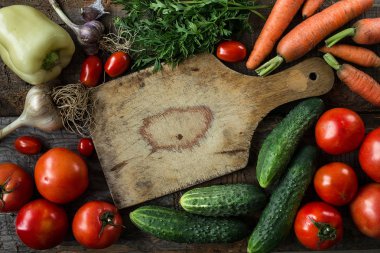 Rustik ayarı, domates, havuç ve salatalık yemek pişirmek için taze malzemeler. Doğal organik sağlıklı gıda kavramı. Üstten görünüm