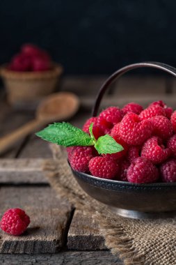 Ahududu rustik tablo ile kırsal natürmort. eski ahşap arka plan üzerinde taze sulu çilek