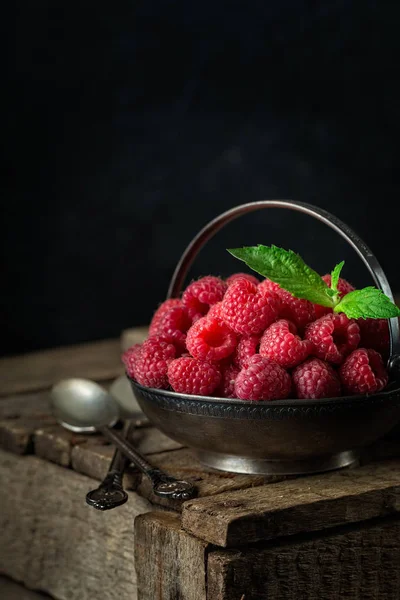 Ahududu rustik tablo ile kırsal natürmort. eski ahşap arka plan üzerinde taze sulu çilek