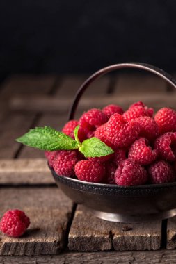 Ahududu rustik tablo ile kırsal natürmort. eski ahşap arka plan üzerinde taze sulu çilek