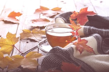 Sonbahar yaprakları ve tabloda çay. tonlama, yumuşak odak