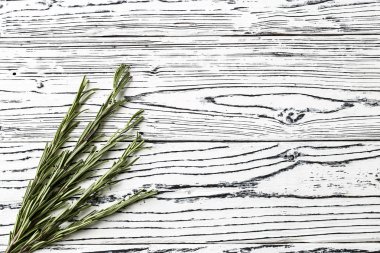 ahşap bir masa üzerinde arka plan rosemary. Ot ve baharat malzemeler ahşap beyaz zemin üzerine