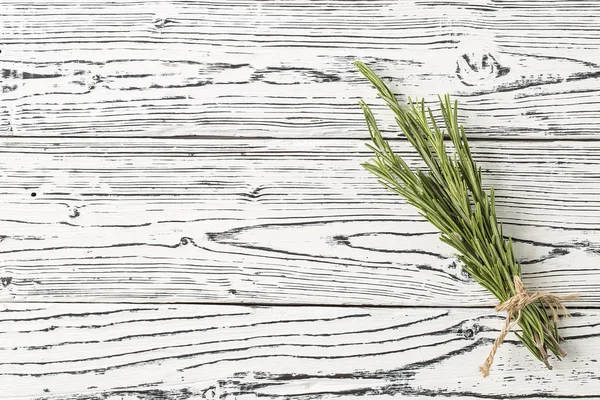 background rosemary on a wooden table. Herb and spice ingredients on  wooden white background