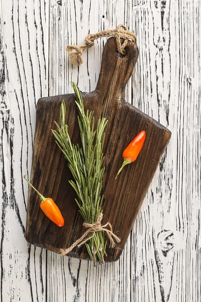 Kesme tahtası, biberiye ve baharat. arka plan biberiye biber ahşap bir masa üzerinde. Ot ve baharat malzemeler ahşap beyaz zemin üzerine