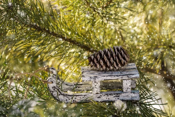 Kerst houten speelgoed sled op winter naaldboom. — Stockfoto