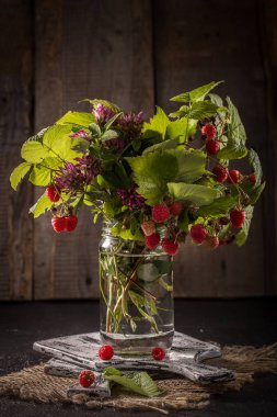     Orman meyveleri rustik arka plan üzerinde yaprakları ile.