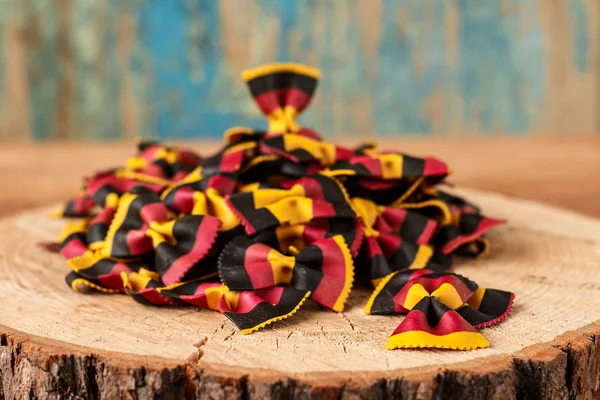 Pâtes italiennes crues multicolores farfalle gros plan sur la table — Photo