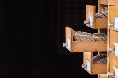 Kütüphane ya da arşiv referans kartı kataloğu. Veritabanı, bilgi tabanı kavramı. Açık kart çekmecesine sahip eski kütüphane veya arşiv referans kataloğu