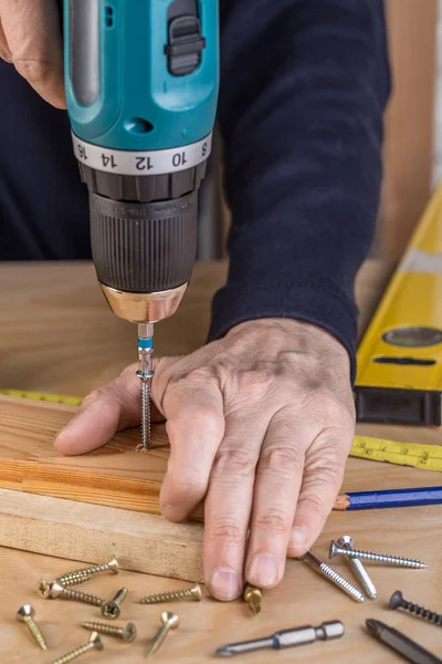 Falegname con cacciavite elettrico. falegname al lavoro fatto a mano — Foto Stock