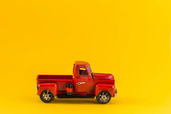 Röd leksaks lastbil på ljusgul bakgrund — Stockfoto