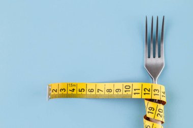 Çatal bir ölçüm bandı, diyet veya sağlıklı beslenme kavramı ile