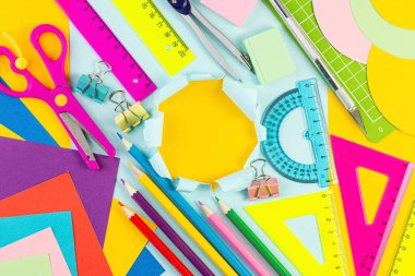 Okul kartına dönelim. Renkli kağıt üzerine çeşitli yazma araçları ve diğer okul kırtasiyeleri. Yaz zamanı, yaratıcılık ve eğitim kavramı. metin veya tasarım için şablon