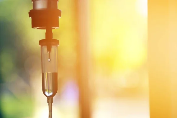 Damardan damar içi sıvı damlası salin damlası hastane odası, tıbbi konsept, tedavi acil durumu ve enjeksiyon ilacı infüzyon tedavisi kemoterapisi, konsept ayarlayın. Mavi ışık arka plan, seçici odaklanma 