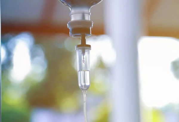 Damardan damar içi sıvı damlası salin damlası hastane odası, tıbbi konsept, tedavi acil durumu ve enjeksiyon ilacı infüzyon tedavisi kemoterapisi, konsept ayarlayın. Mavi ışık arka plan, seçici odaklanma 