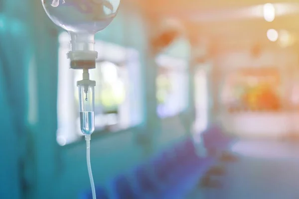 Damardan damar içi sıvı damlası salin damlası hastane odası, tıbbi konsept, tedavi acil durumu ve enjeksiyon ilacı infüzyon tedavisi kemoterapisi, konsept ayarlayın. Mavi ışık arka plan, seçici odaklanma 