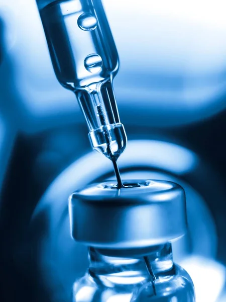 Aşı tüpü doz aşısı iğne şırıngası, tıbbi konsept şırınga enjeksiyon enjeksiyonu hastalık tedavisi, hastane bakımı, bağışıklık hastalığı bebek. Mavi arka plan. 