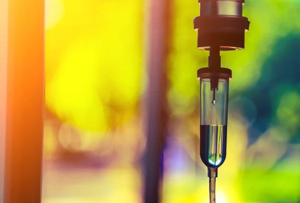 Damardan damar içi sıvı damlası salin damlası hastane odası, tıbbi konsept, tedavi acil durumu ve enjeksiyon ilacı infüzyon tedavisi kemoterapisi, konsept ayarlayın. Mavi ışık arka plan, seçici odaklanma 