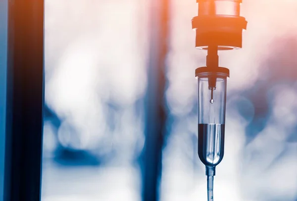 Damardan damar içi sıvı damlası salin damlası hastane odası, tıbbi konsept, tedavi acil durumu ve enjeksiyon ilacı infüzyon tedavisi kemoterapisi, konsept ayarlayın. Mavi ışık arka plan, seçici odaklanma 