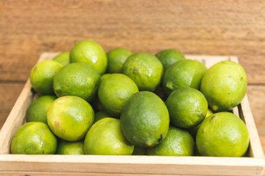 Tahta tabanda taze yeşil limonlar