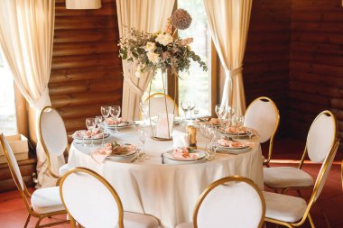 Süslü masaları olan bir düğün uçağı. Taze çiçekler ve otlarla süslenmiş bir tabak. Kapat.