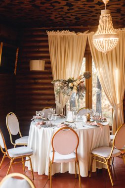 Boş şarap kadehleriyle şenlik masası ayarları. Restorandaki beyaz ve kırmızı masada pembe peçeteler, beyaz tabaklar ve şarap kadehleriyle kutlama ziyafeti