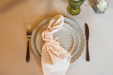 Boş şarap kadehleri ve tabağı olan en iyi manzara masa ayarı. Lokantadaki beyaz masada beyaz ve kırmızı şarap için tabaklar ve şarap kadehleriyle kutlama ziyafeti