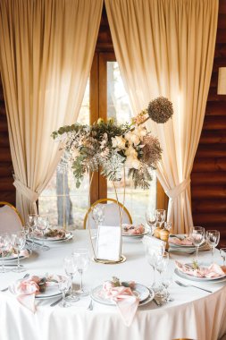 Süslü plakalı düğün uçağı. Şarap kadehleri ve otlarla süslenmiş bir masa.