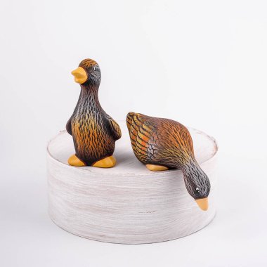 İki seramik ördek kütükte kalır ve aşağı bakar ve geleceğe bakar. Bahçe için izole edilmiş kahverengi ördekler