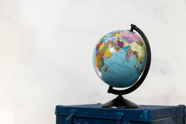 Seyahat ya da turizm konsepti. Mavi bavulda izole edilmiş bir küre. Boşluğu kopyala
