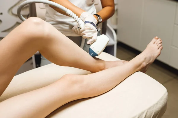 Laser epilation and cosmetology in beauty salon. Hair removal procedure. Laser epilation, cosmetology, spa, and hair removal concept. Beautiful woman getting hair removing on legs