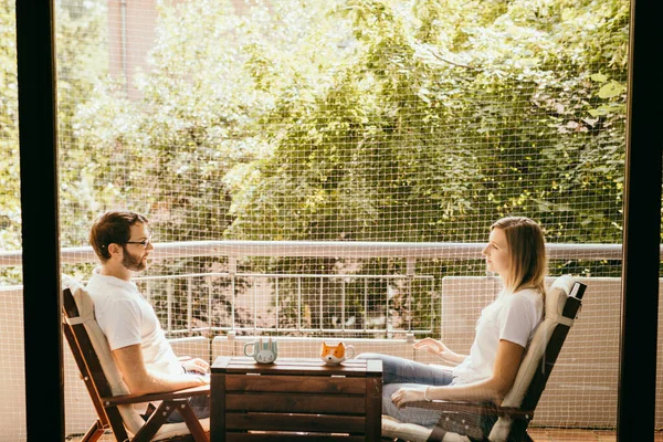 Happy couple sitting on wood table. Lovely family on balcony at home with nature background