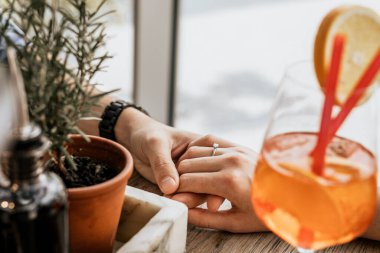 Masada el ele tutuşan mutlu genç bir çiftin görüntüsü. Restoranda romantik bir akşam yemeği.
