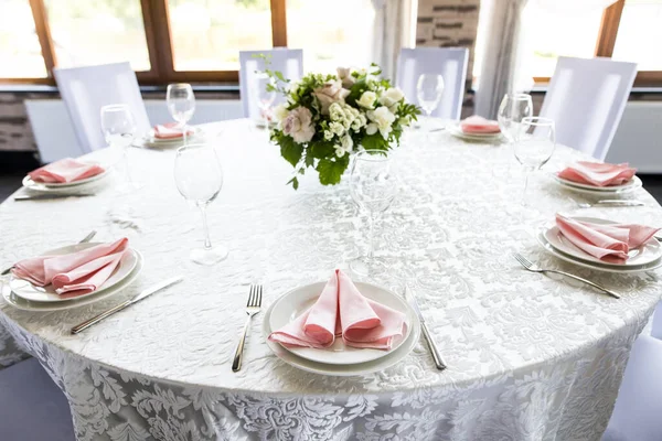 Feestelijke tafelschikking met wijnglazen en verse bloemen — Stockfoto