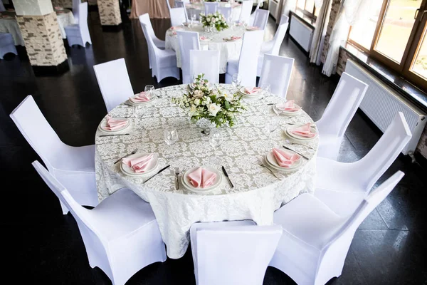 Feestelijke tafelschikking met wijnglazen en verse bloemen — Stockfoto