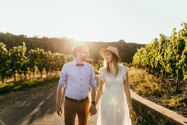 Casal elegante andando entre a vinha e olhar um para o outro — Fotografia de Stock