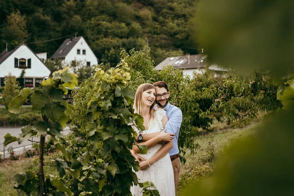 Lächelndes Paar steht inmitten von Weinbergen — Stockfoto