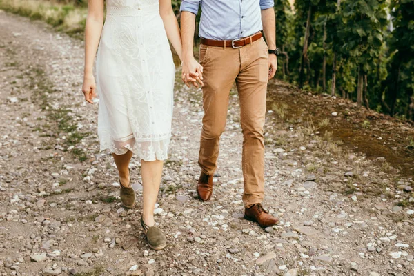 Romantisches Paar hält Händchen auf grünem Gras — Stockfoto