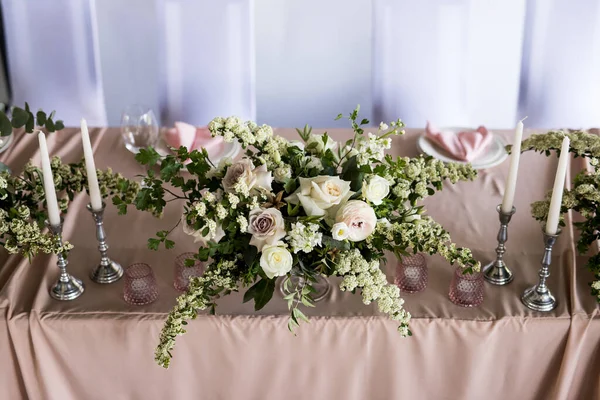 Restoranda taze beyaz güllü gelin ve damat için başkanlık makamının en iyi manzarası. Yeni evliler için lüks düğün ziyafetini kapatın.