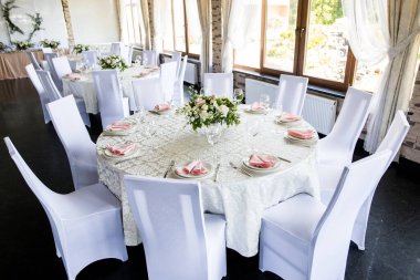 Şarap kadehleri ve taze çiçeklerle şenlik masası.