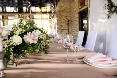 Düğünde yeni evlilerin başkanlık kürsüsünün yan görüntüsü. Restoranda beyaz güllü gelin ve damat için bir masa. Lüks düğün ziyafeti dekorasyonu