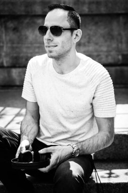 Elinde kulaklıkla gülümseyen bir adamın portresi, başka yere bak. DJ 'in siyah beyaz fotoğrafı.