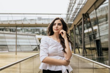 Beyaz bluz ve siyah pantolon giyen güzel ve çekici bir kadın içeri bakıyor. İnşaat geçmişinde genç bir kadın