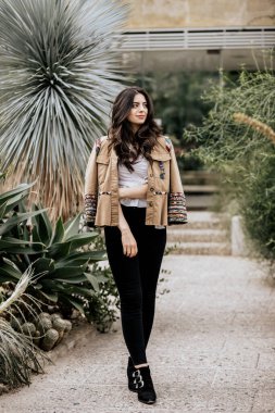 Bej renkli ceket giyen güzel ve çekici bir kadın başka tarafa bakıyor. Doğası gereği genç bir kadın.