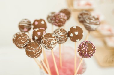 Pembe ve beyaz süslemeli küçük tatlı çörekleri kapatıyoruz. Düğün şekeri.