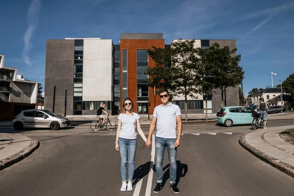 Casal elegante em branco T-shirt sorrindo stand ao ar livre — Fotografia de Stock