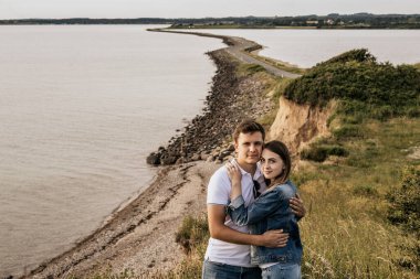 Ambrance 'deki romantik çift sahilde dağlarla dikiliyor. Seyahat yaşam tarzı konsepti