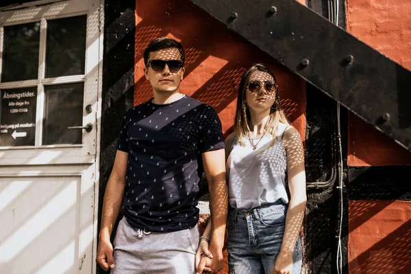 Romantik çift el ele tutuşup gözlerini kaçırıyor. Mutlu adam ve kadın bina geçmişinde