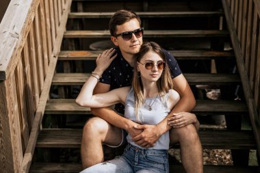 Embrance 'daki romantik çifti yakından takip edin ve binanın arka planına bakmayın. Mutlu adam ve kadın tahta merdivenlerde oturuyor.