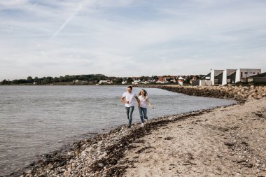 Romantik çift el ele tutuşup plajda koşuyor. Seyahat yaşam tarzı konsepti